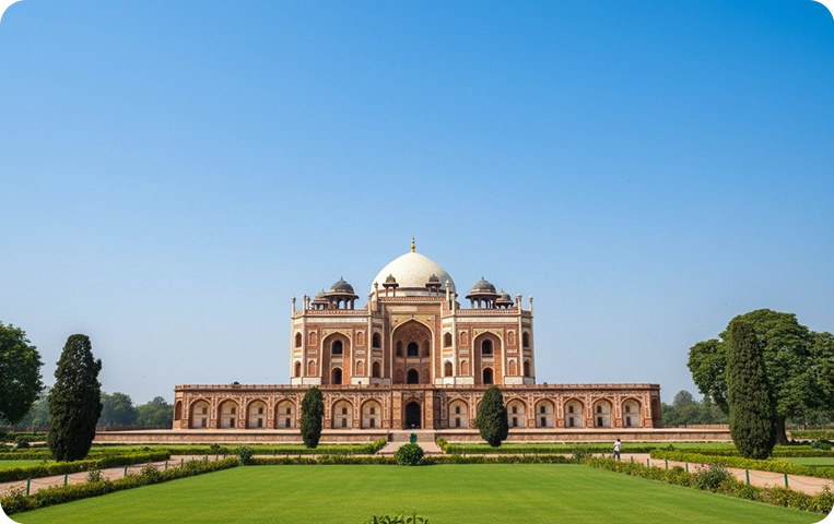 Historic mausoleum with gardens under clear sky.