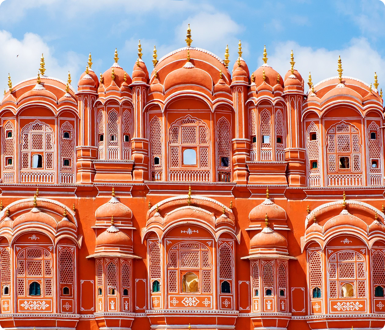 Ornate pink palace facade under blue sky.